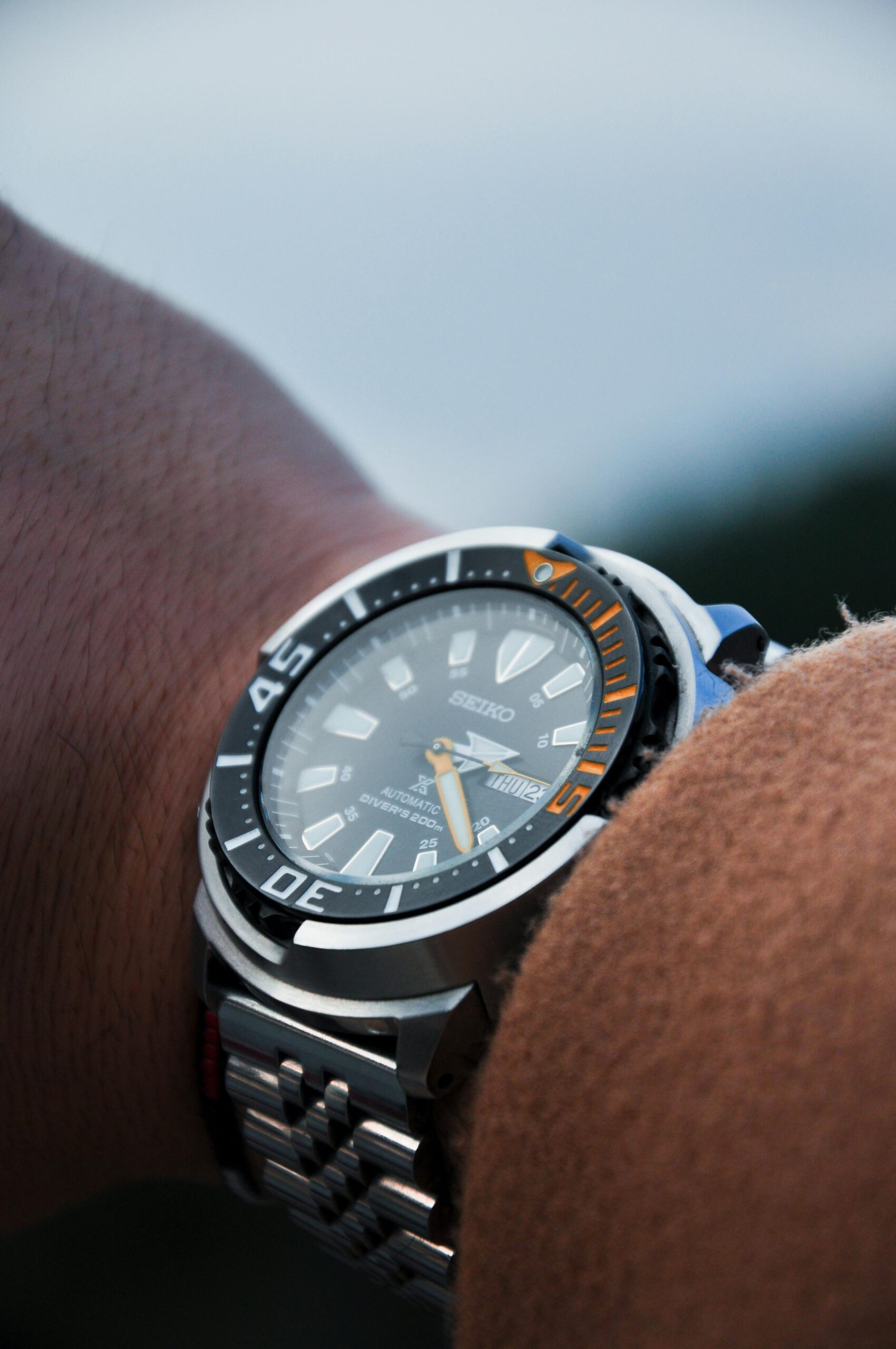 Detailed view of a wristwatch on a person's arm, showcasing its design.